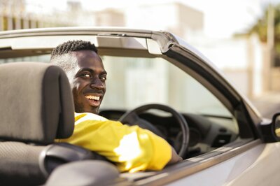 Ein Mann sitzt in seinem Auto Abo und schaut über die Schulter